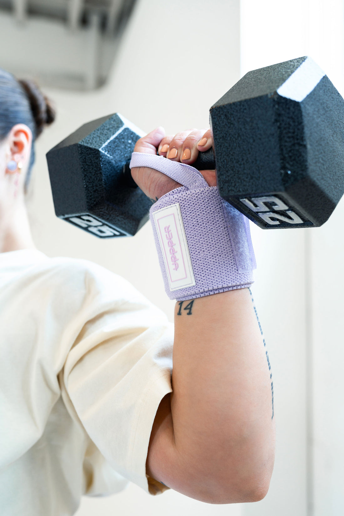 woman doing shoulder press with uppper wrist wraps